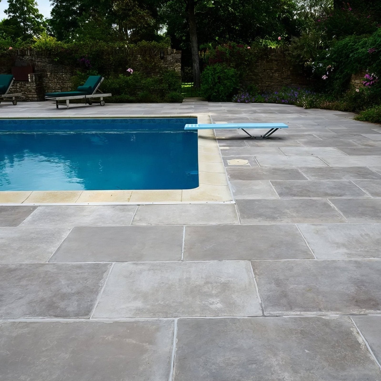 Light blue diving board with sleek metal supports featured alongside Provence Paving porcelain cenere tiles