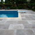 Light blue diving board with sleek metal supports featured alongside Provence Paving porcelain cenere tiles