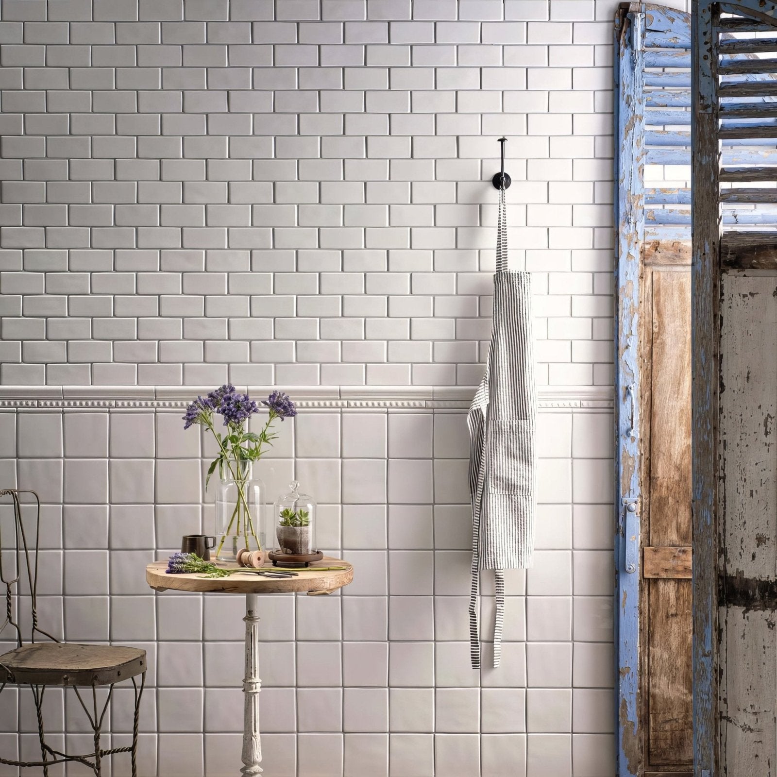 A black and white striped apron hanging from a hook next to a pure white semi round pencil product display