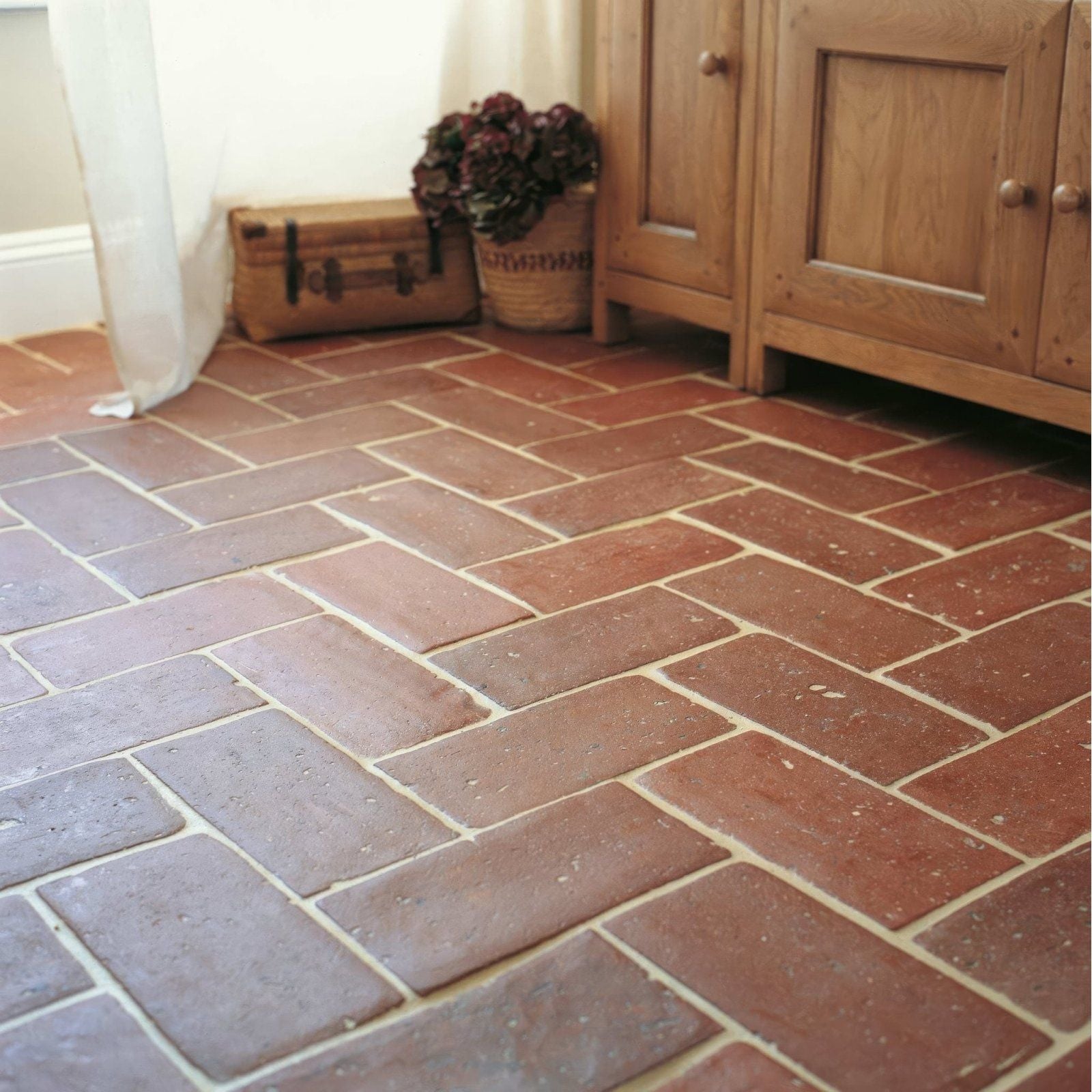 Reclaimed terracotta square tile 15x15 with reddish-brown color laid in a herringbone pattern for flooring use
