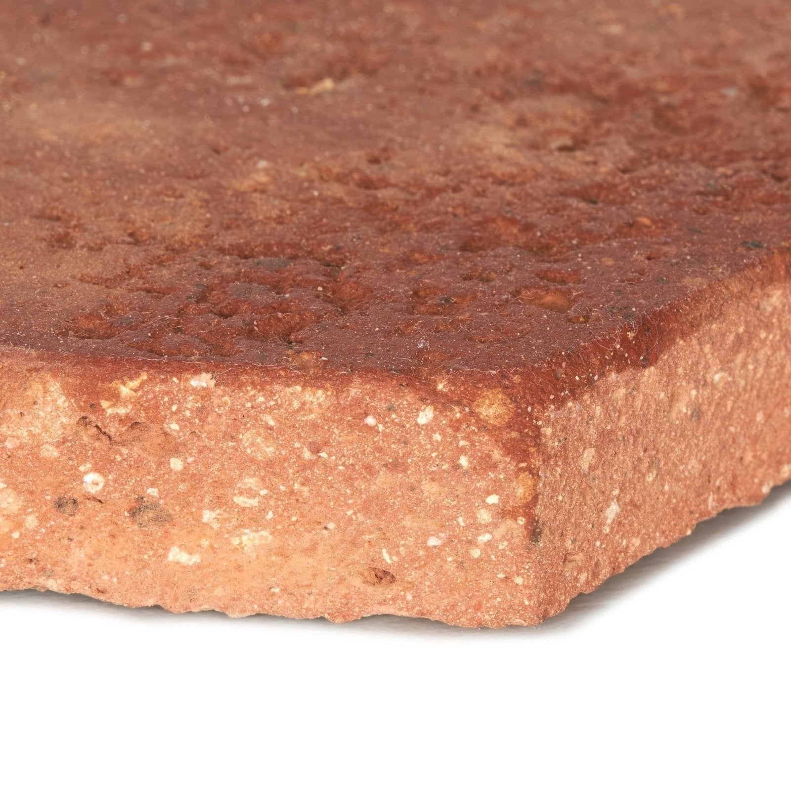 A reclaimed terracotta hexagonal tile in rustic reddish-brown with textured surface and visible aggregate particles in mortar