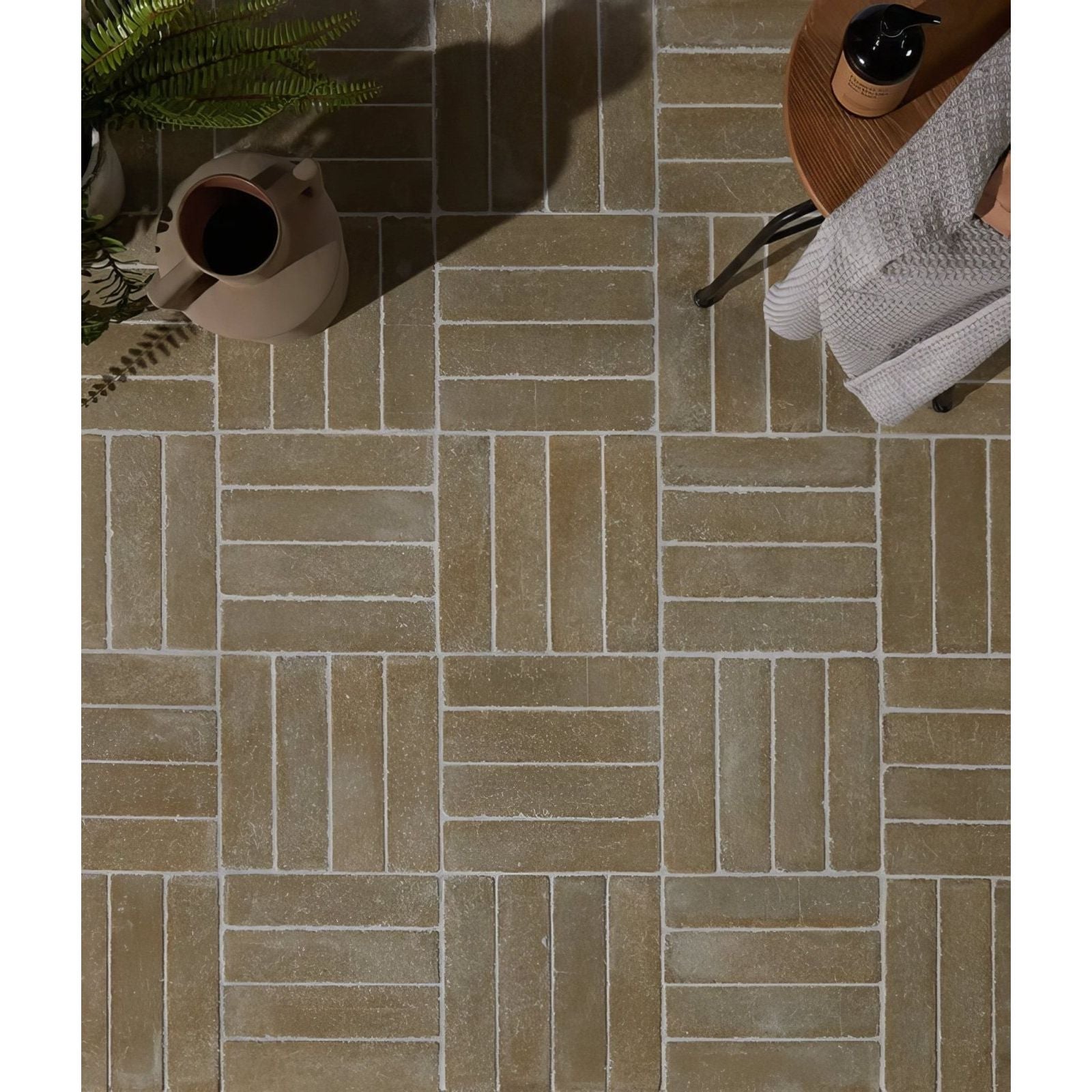 Beige rectangular reform composite stone tumbled khaki tiles with subtle texture in interlocking herringbone pattern