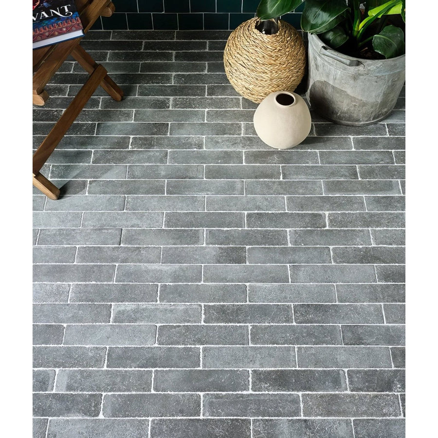 Dark gray rectangular brick-style reform composite stone tumbled nero floor tiles with textured weathered finish