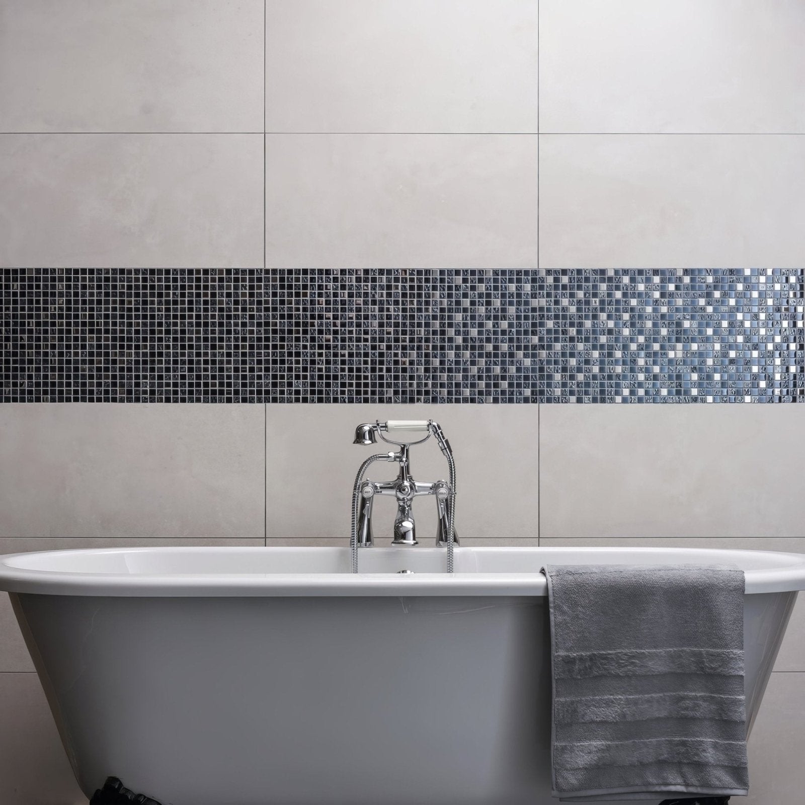 Rena Earth and Fire Mixed Mosaics blue and grey glass mosaic with a white clawfoot bathtub