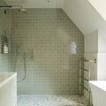 The bathroom wall is covered in retro metro gloucester road 7.5 x 15 sage green glazed subway tiles in a brick pattern