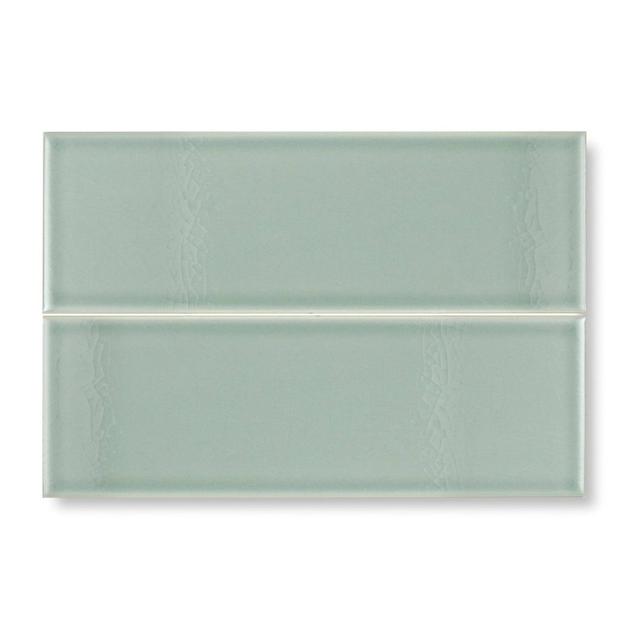 Two rectangular glazed glass tiles in soft sage green with subtle textured patterns retro metro lime house 10 x 30