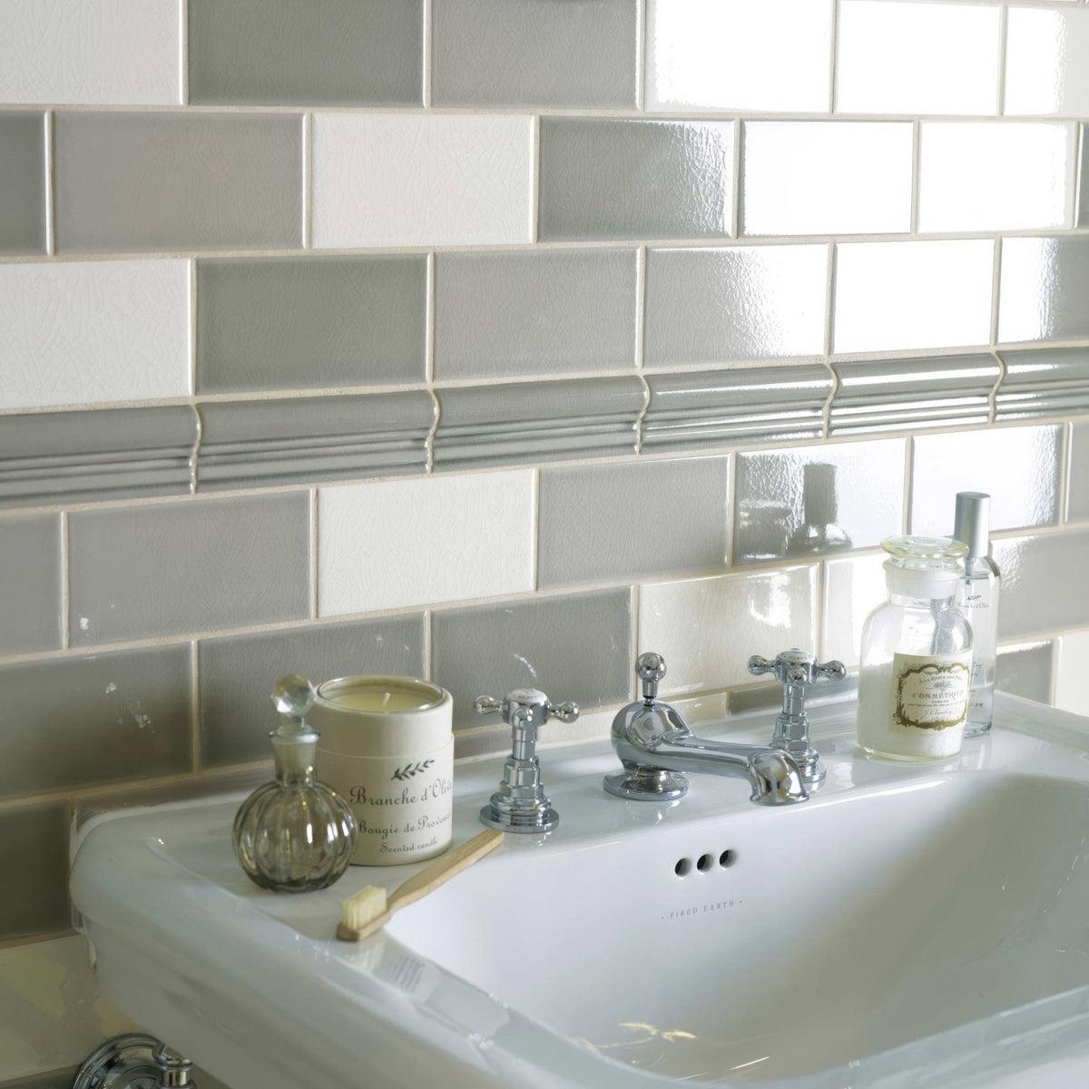Chrome finished vintage style bathroom faucet with ornate cross handles and central spout on retro metro south kensington glazed tile