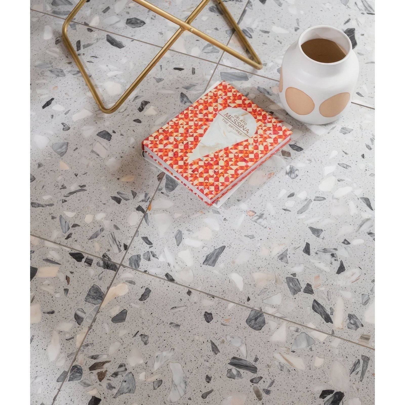Rialto Terrazzo Castello Honed grey terrazzo tiles with a patterned notebook
