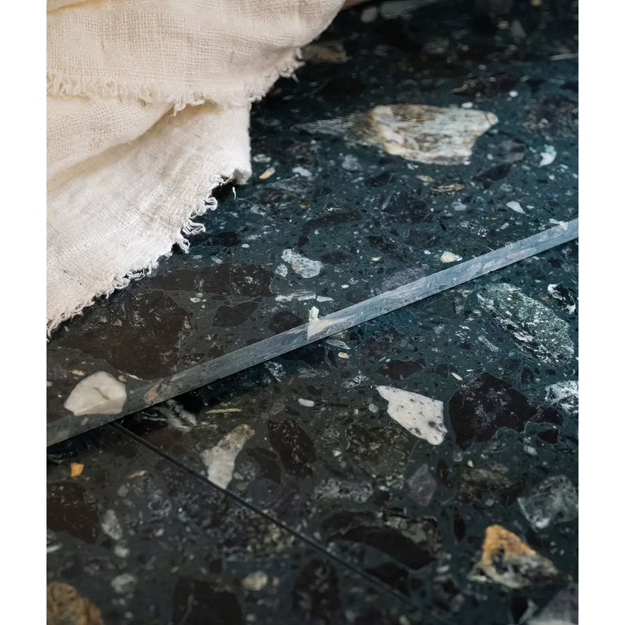 A sleek dark green rialto terrazzo foscari honed tile with white and black stone speckles