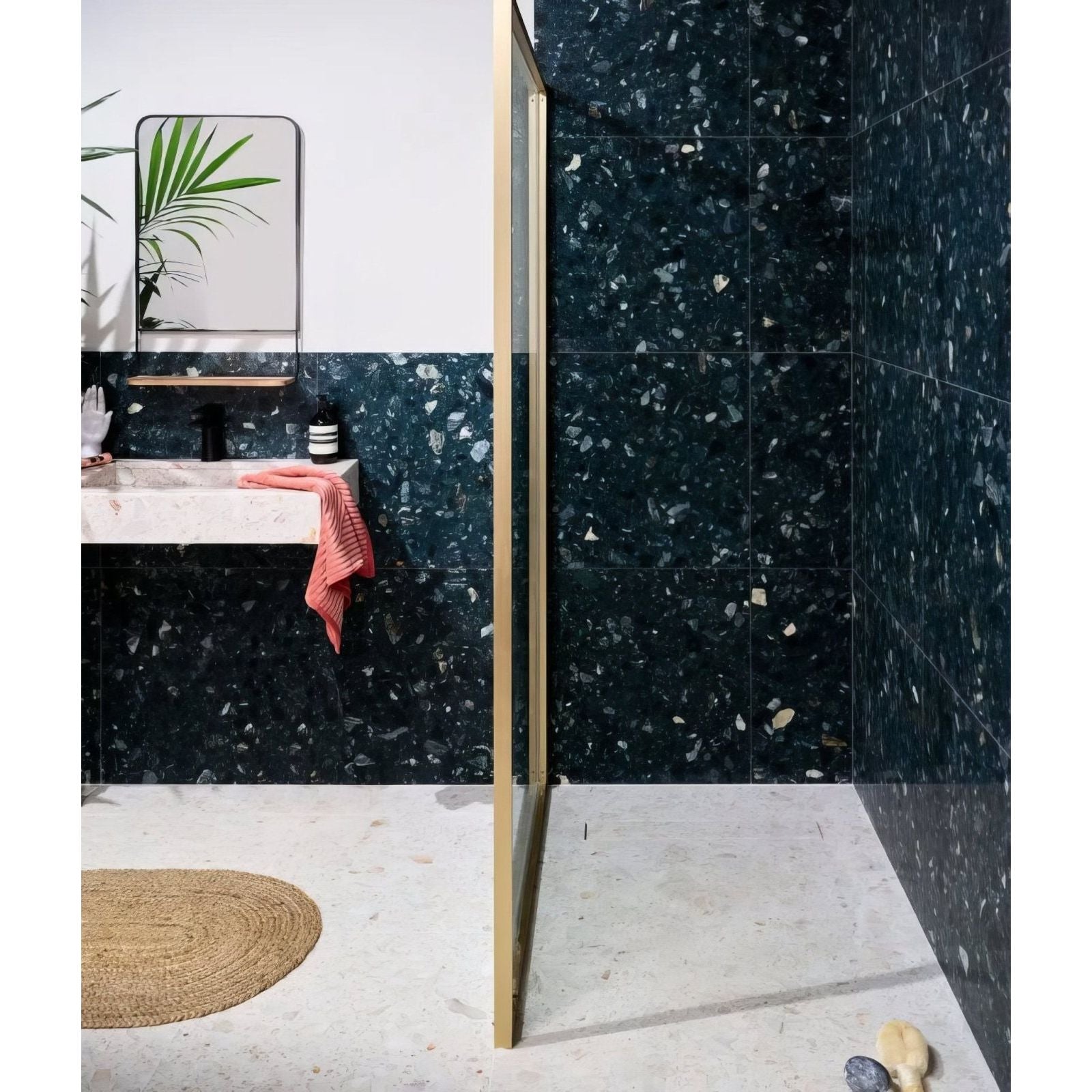 Dark green rialto terrazzo foscari honed tiles with white and beige flecks covering bathroom walls