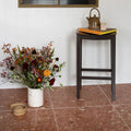 Rialto Terrazzo Santa Croce Honed red terrazzo tiles with a floral arrangement