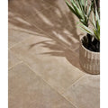 Beige riviera limestone tumbled stone tile with subtle natural texture next to a geometrically faceted planter