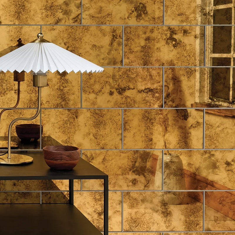 Rococo glass mirror brass with gold toned textured wall tiles featuring a distressed vintage patina finish