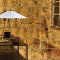 Rococo glass mirror brass with gold toned textured wall tiles featuring a distressed vintage patina finish