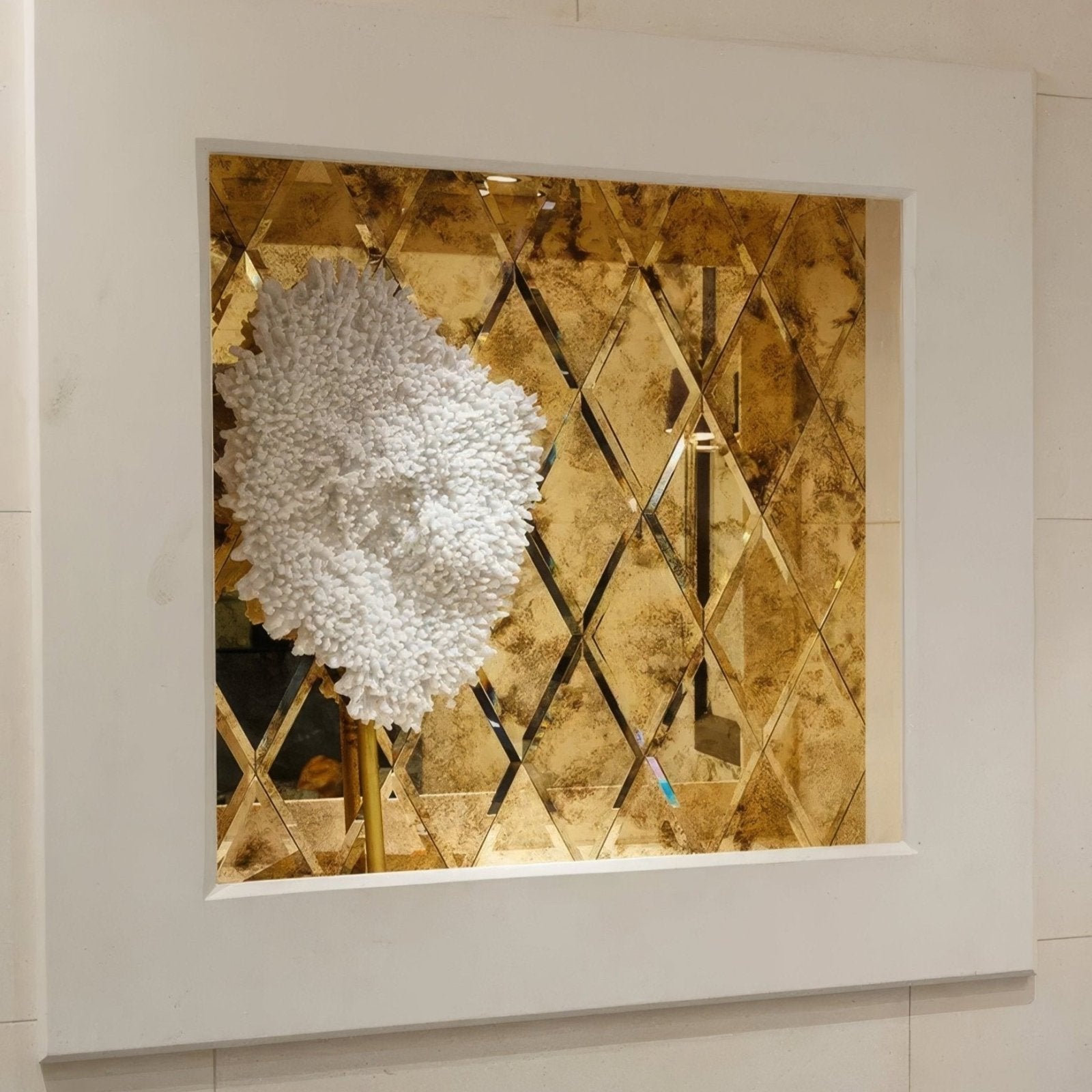 Rococo mirror with diamond glass and brass frame featuring a white fluffy textured floral sculpture centerpiece