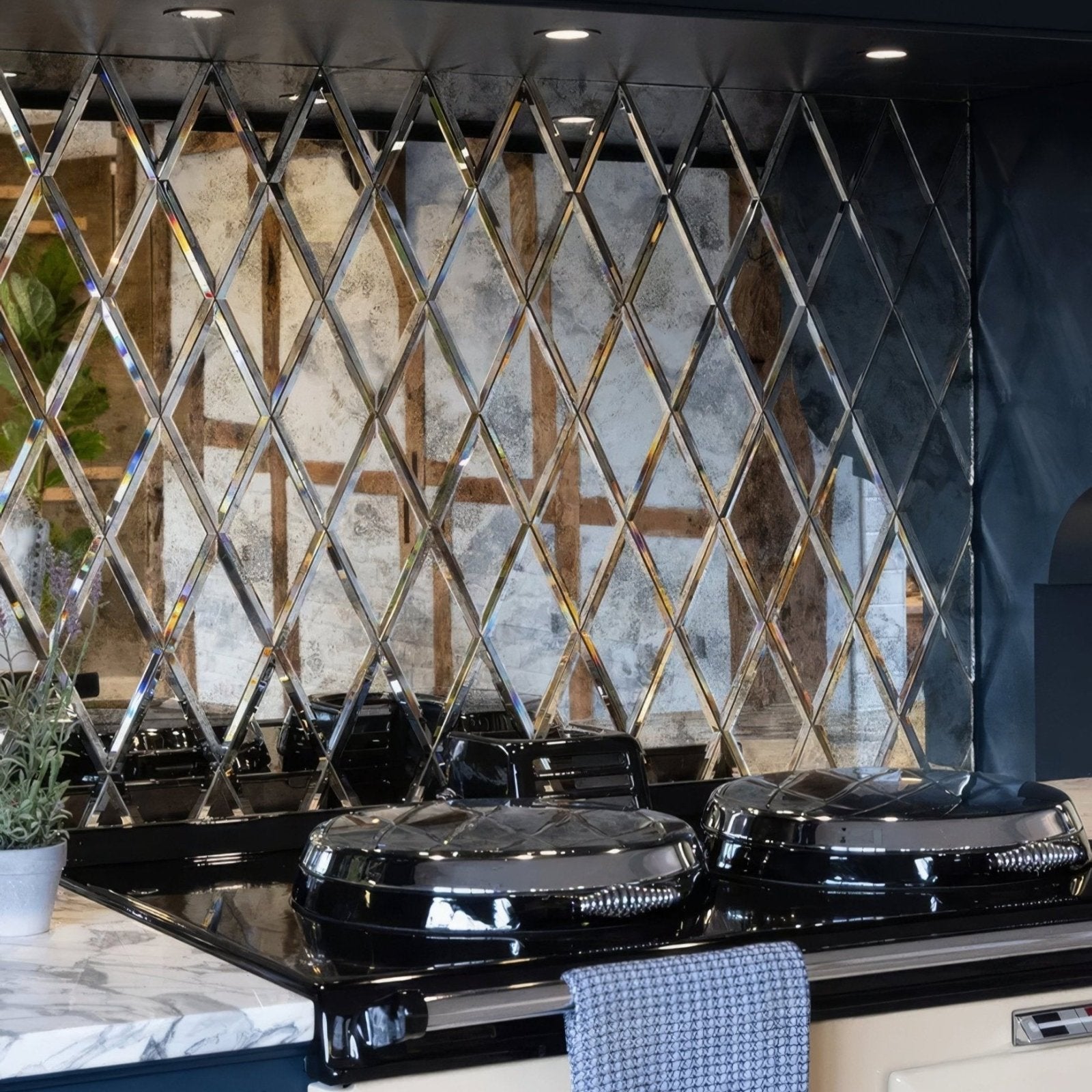 Black ceramic cooktop with glossy finish and diamond-patterned mirrored backsplash from rococo mirror diamond glass mercury