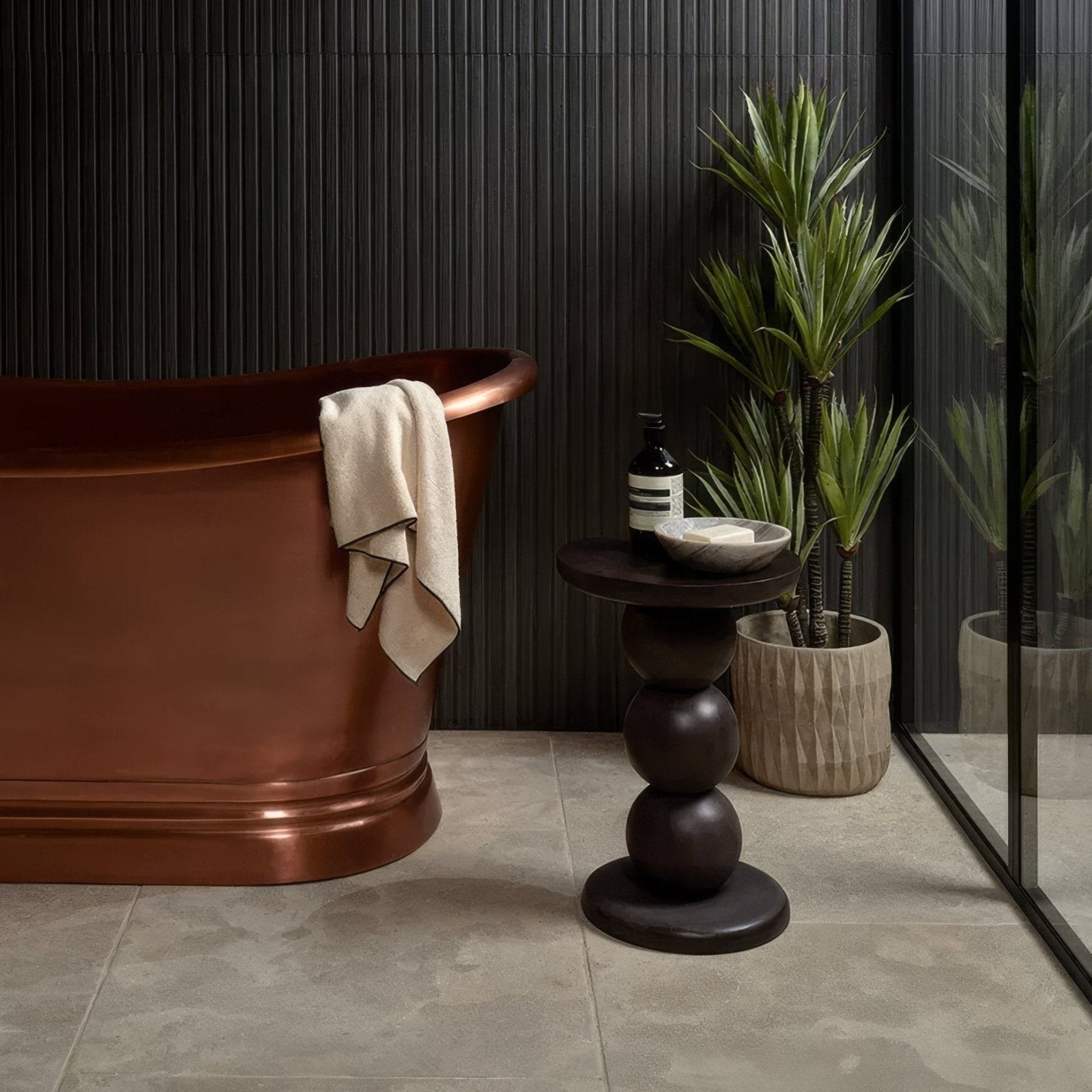 Copper freestanding bathtub with smooth polished finish and rounded edges in Romaine limestone velvet finish design