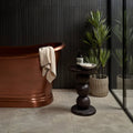 Copper freestanding bathtub with smooth polished finish and rounded edges in Romaine limestone velvet finish design