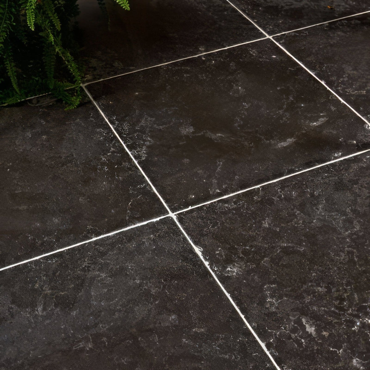 Royal mink limestone tumbled finish dark gray stone tiles with subtle veining separated by white grout lines
