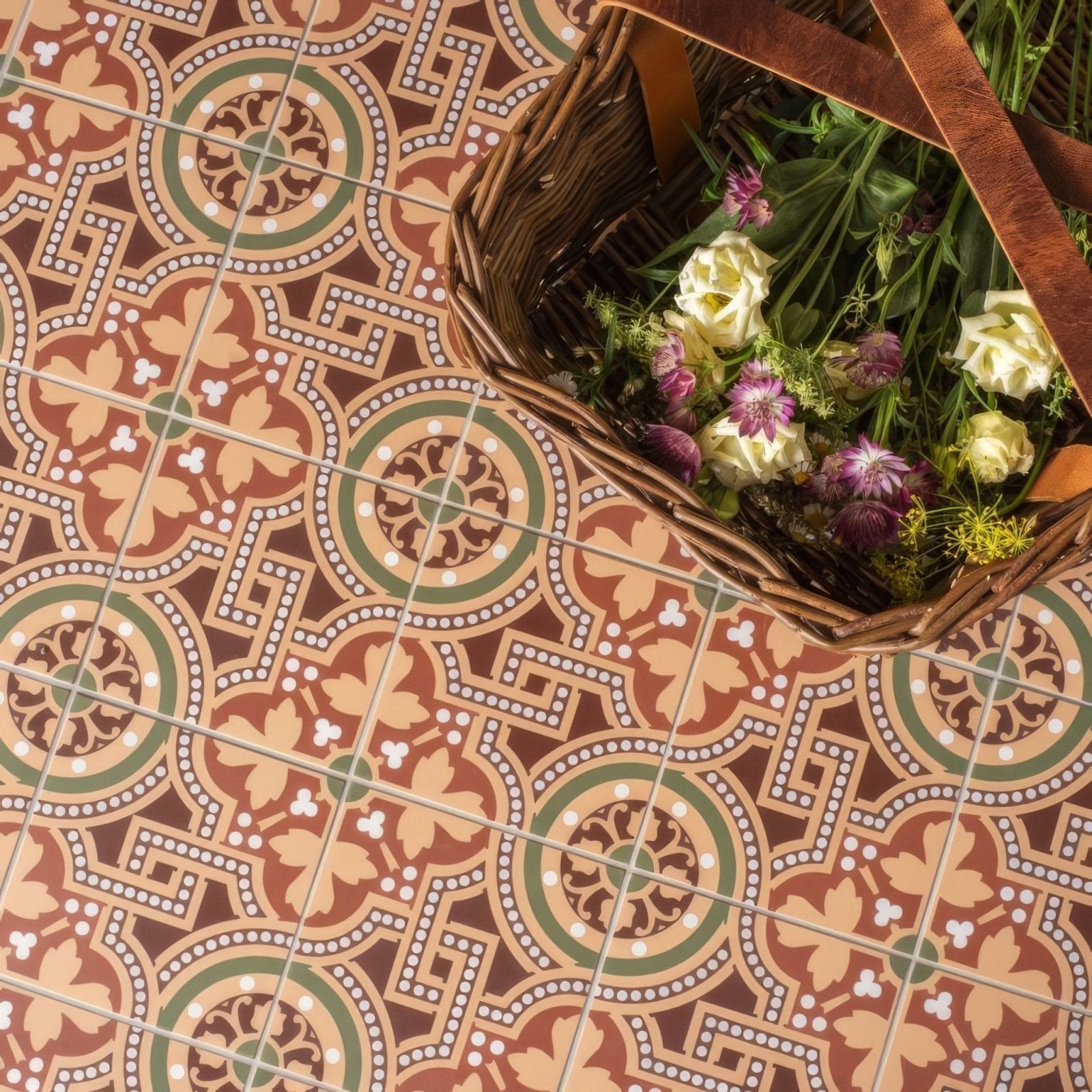 Woven wicker basket with brown leather handles filled with white and purple flowers in salisbury green on buff