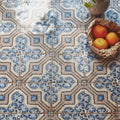 A sardinia porcelain gioia basket lined with brown paper holding three vibrant orange citrus fruits