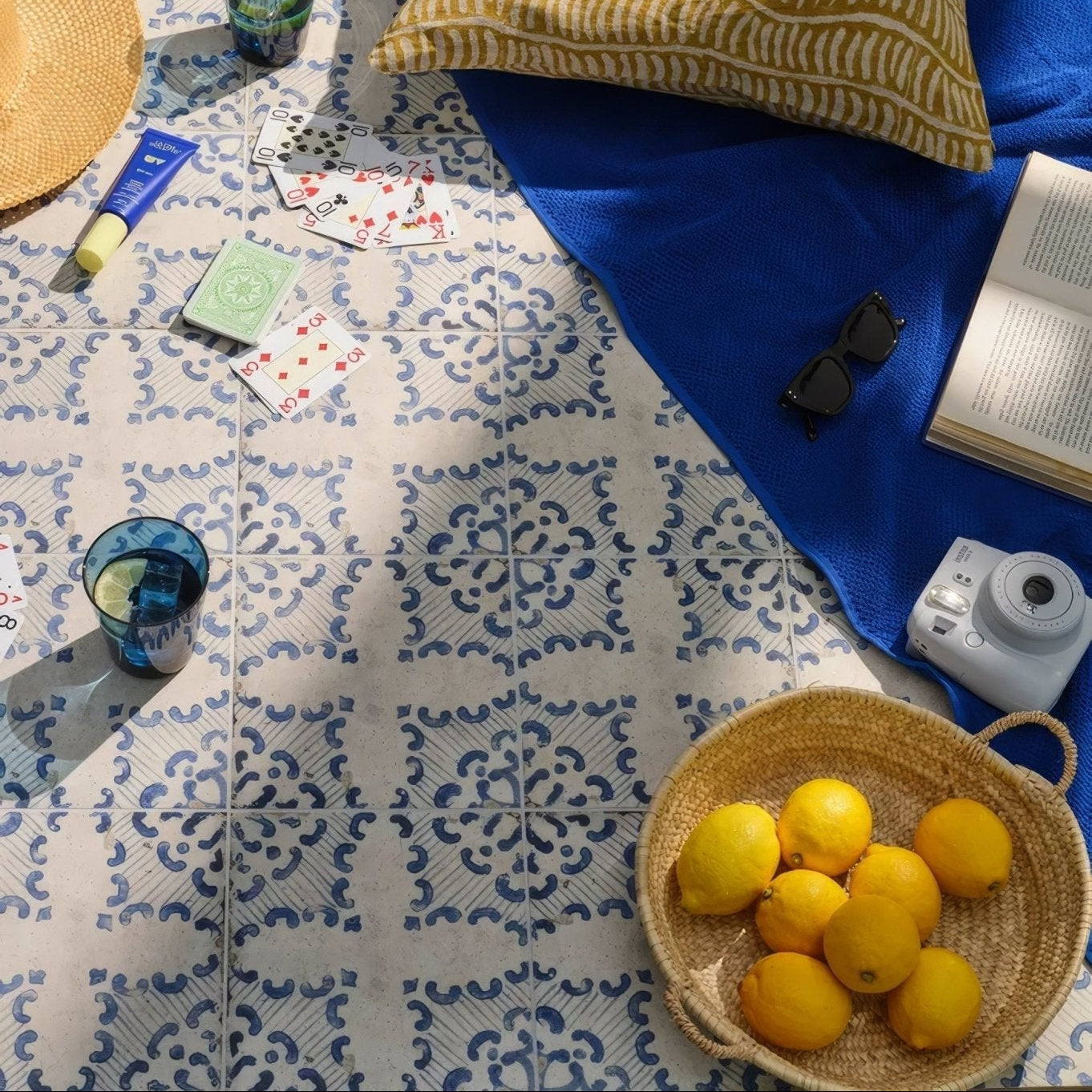 Woven wicker basket filled with bright yellow lemons featured in sardinia porcelain tarricone product display