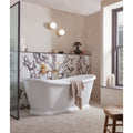 Savoy Porcelain white marble-effect tiles with a freestanding bathtub and towel