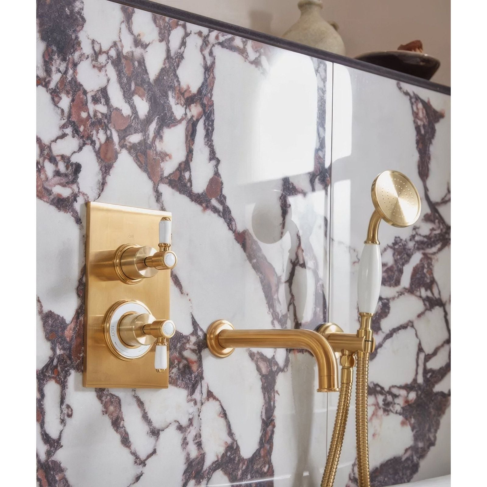 Savoy Porcelain white marble-effect tiles with a gold tap and showerhead