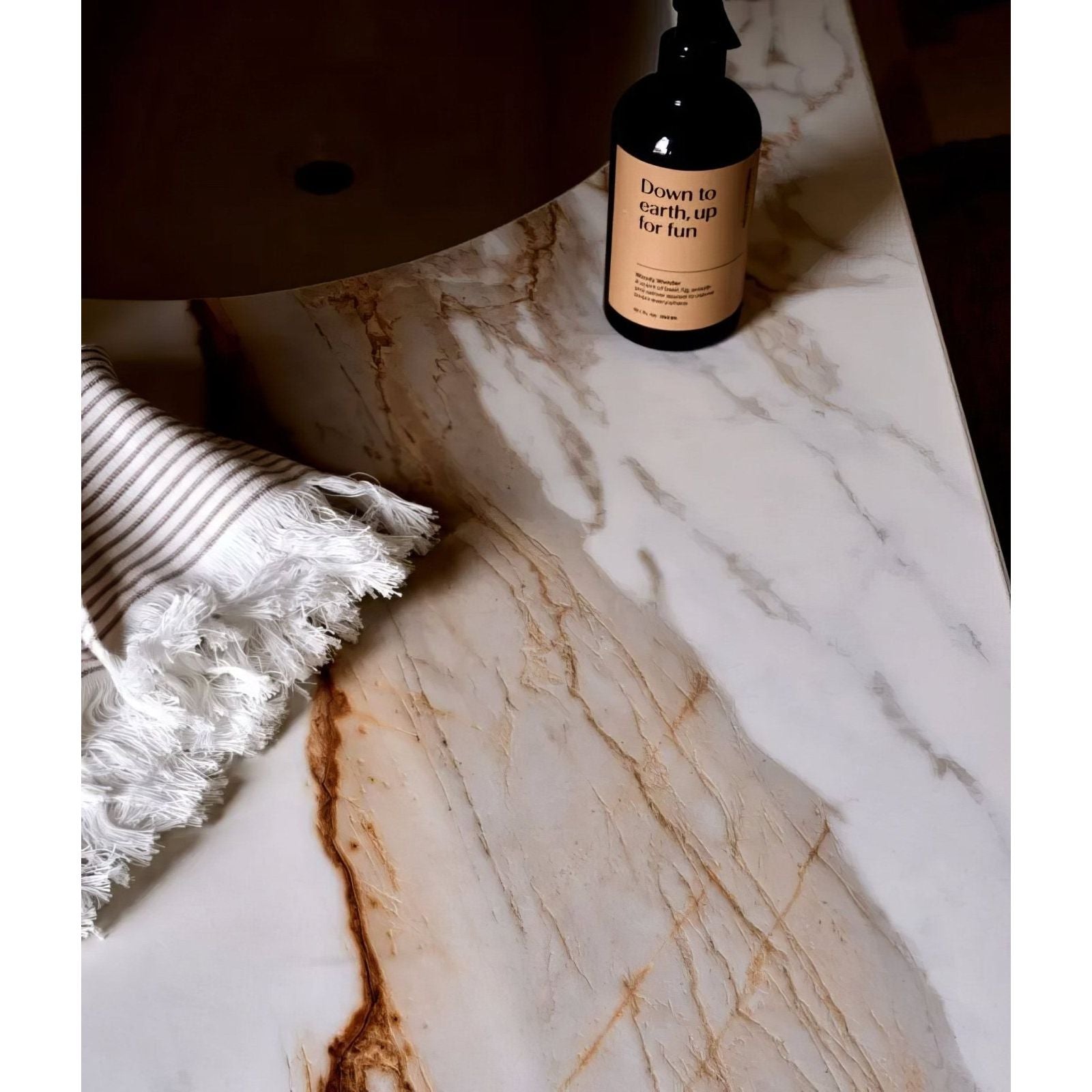 Sculpture Grande Porcelain Calacatta Maximus white marble-effect tiles with a black spray bottle