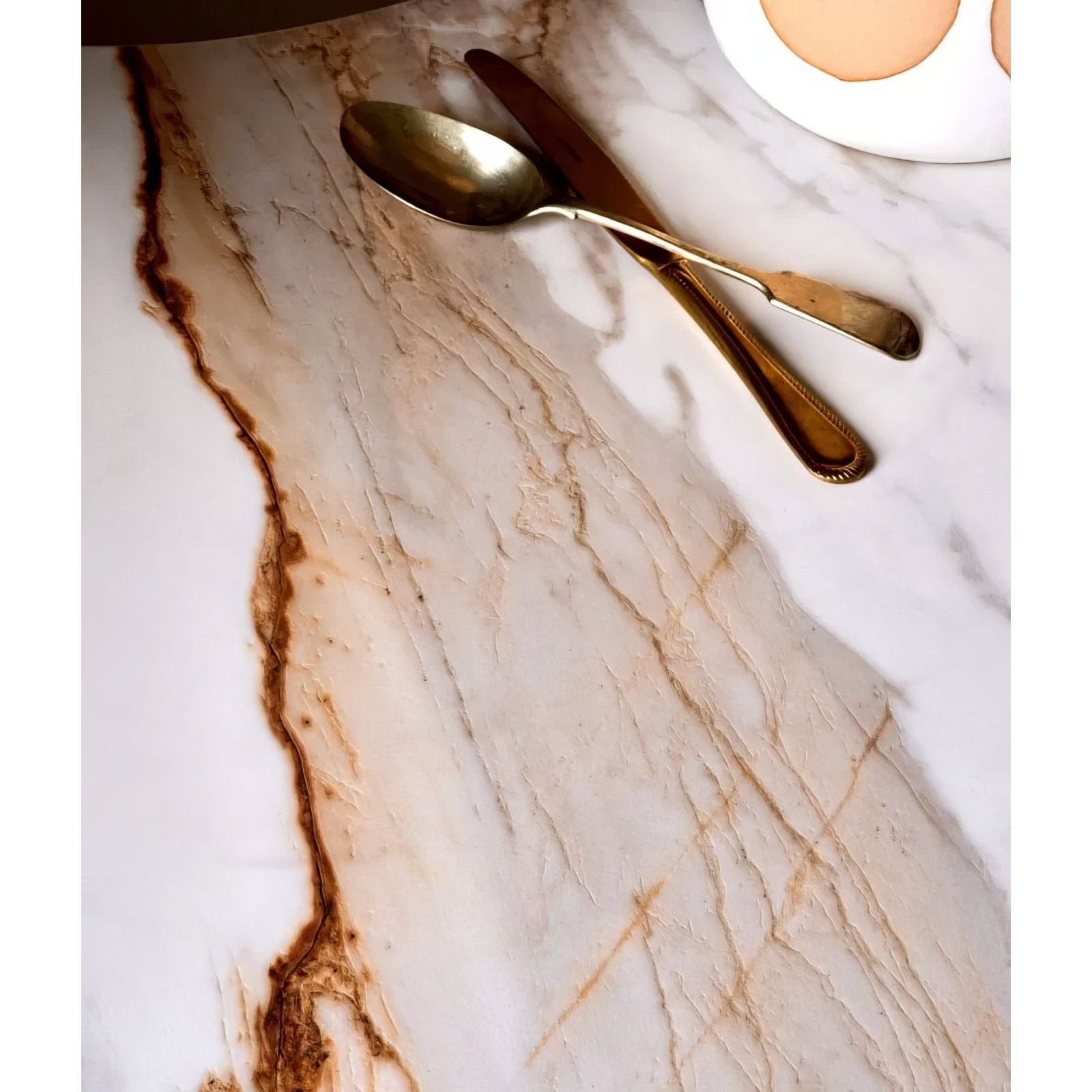Sculpture Grande Porcelain Calacatta Maximus white marble-effect tiles with a gold cutlery set