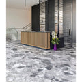 Sculpture Grande Porcelain Ceppo grey terrazzo-effect tiles with a purple vase of orchids