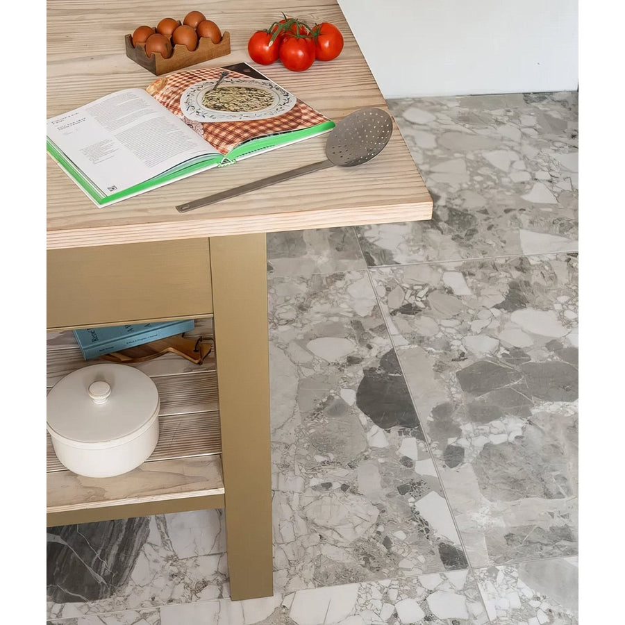 Sculpture Grande Porcelain Ceppo grey terrazzo-effect tiles with a wooden table and cookbook