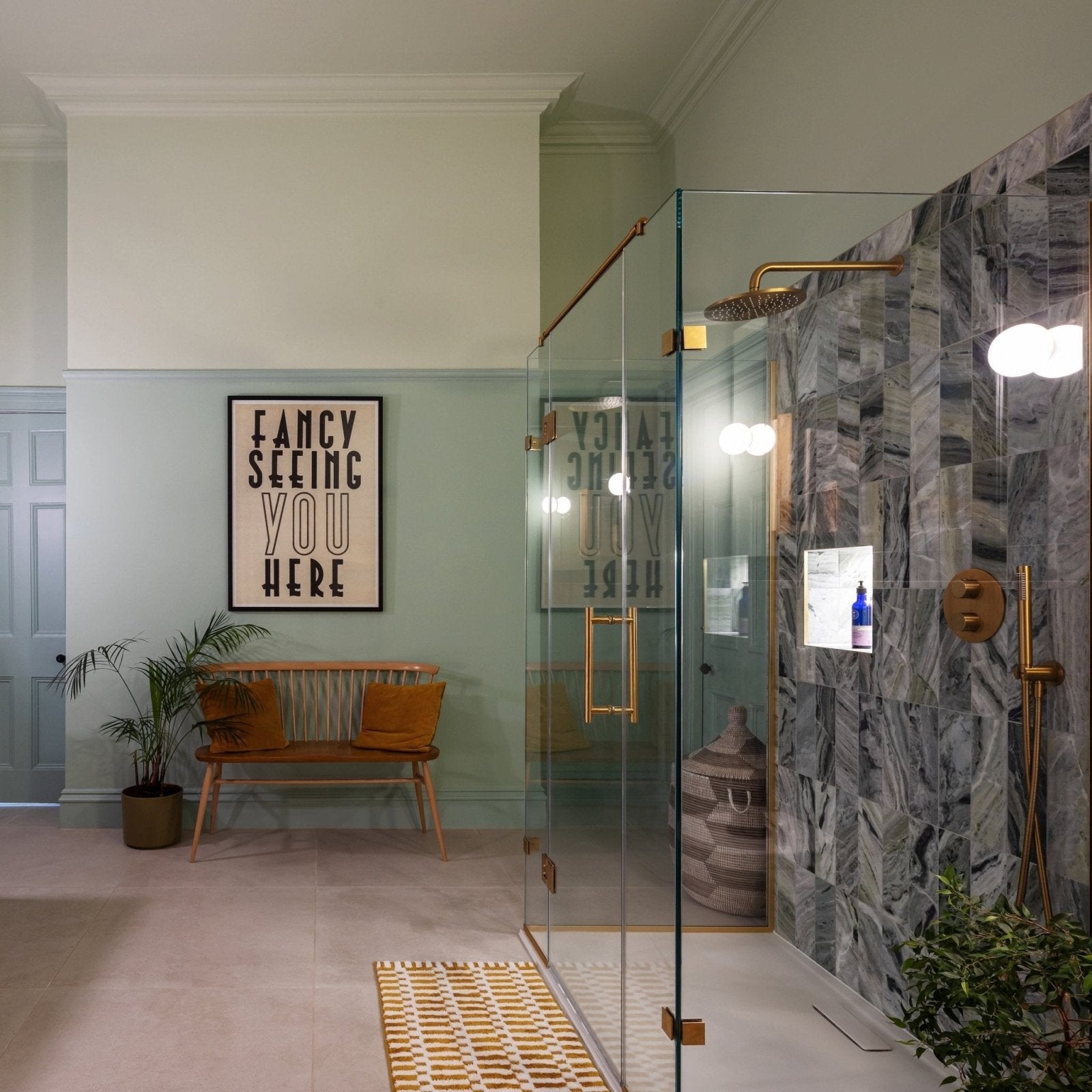 Modern glass shower enclosure with brass fixtures against seaspray green marble tile 10 x 30cm wall panel