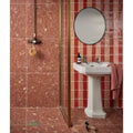White ceramic Seaton marmalade pedestal sink with rectangular basin and fluted base against red tiled walls