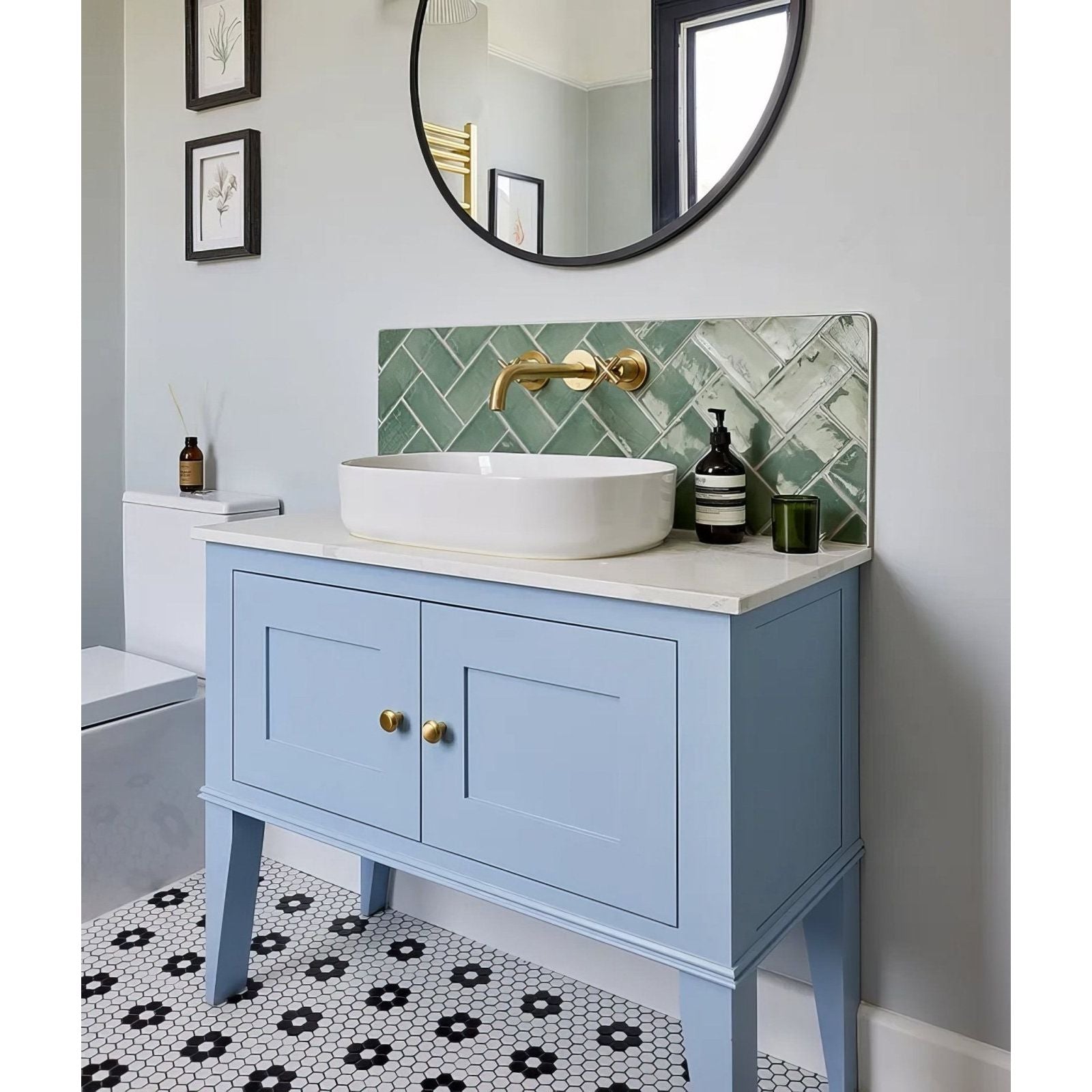 Seaton ceramic sea cabbage light blue painted vanity with gold hardware and white sink against green herringbone tile