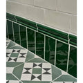 Deep green glossy seaton ceramic sea grass tiles with decorative molded border lining the wall