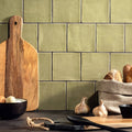 Olive-green ceramic subway field tile sedge with a matte finish and dark grout lines for wall or backsplash use