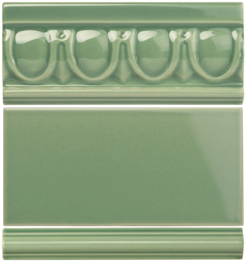 Set of three sage green ceramic tiles featuring a decorative molded border tile, a plain rectangular tile, and a simple grooved baseboard tile.