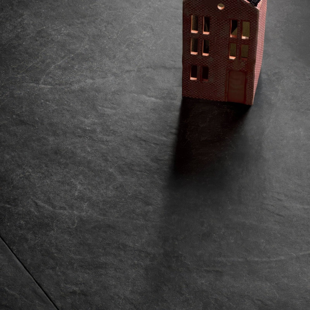 A miniature red brick house model with gold-trimmed windows and a circular roof detail in shale black 30 x 60cm