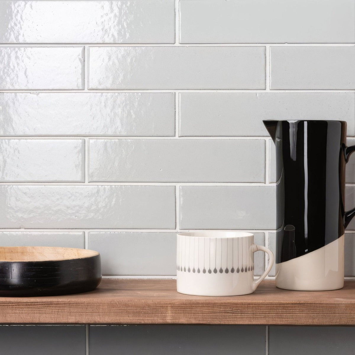 A sleek black and white ceramic pitcher with a glossy finish and bold diagonal split design in shell smooth brick tile style