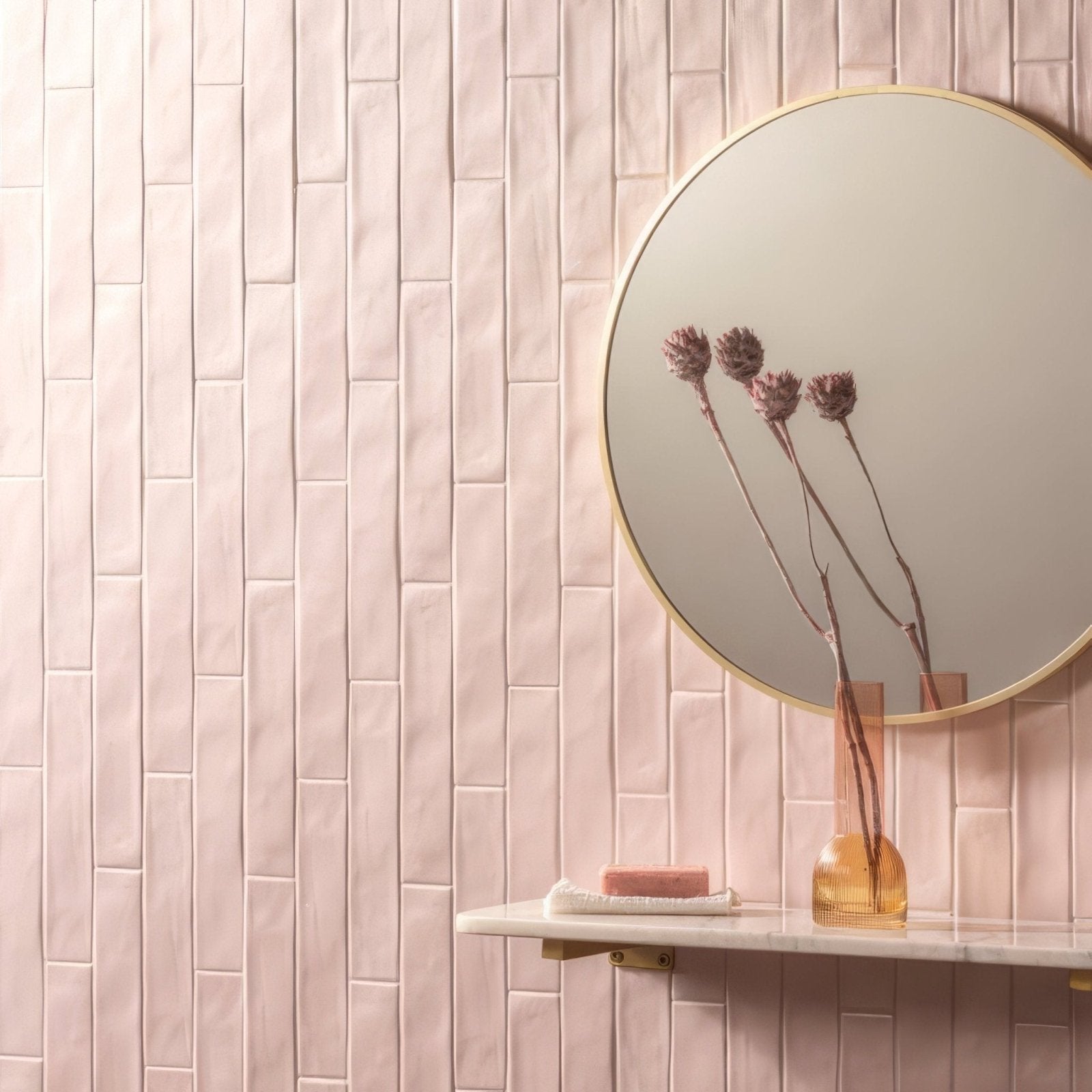 A round sherbet pink brick 5x25cm tile with a thin gold frame shown as a mirror accessory