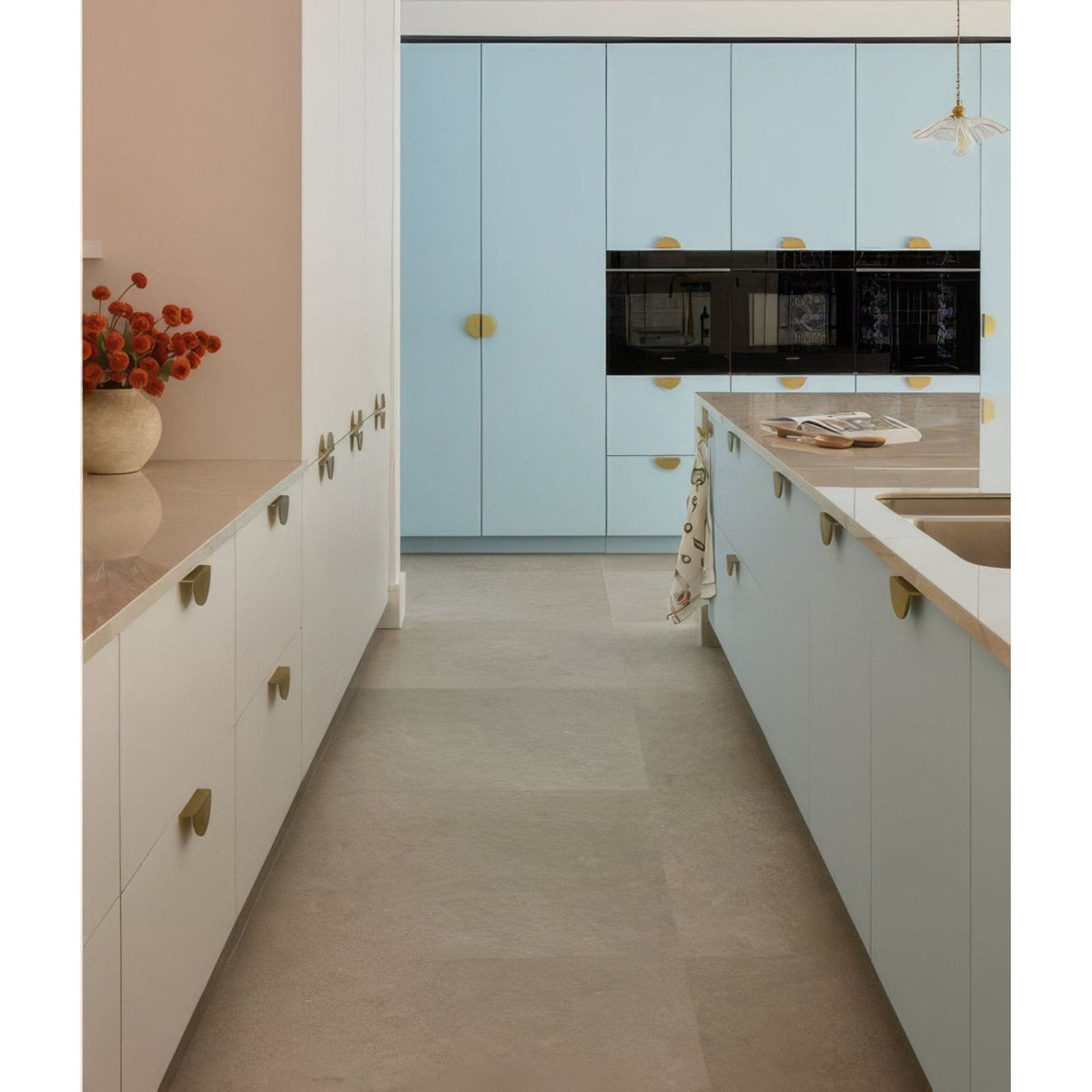 Light blue sherborne porcelain kitchen cabinets with gold circular handles and black built-in appliances