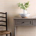 A white ceramic pitcher with a hammered texture and brown base on a gray wooden console table in shore brick tile decor