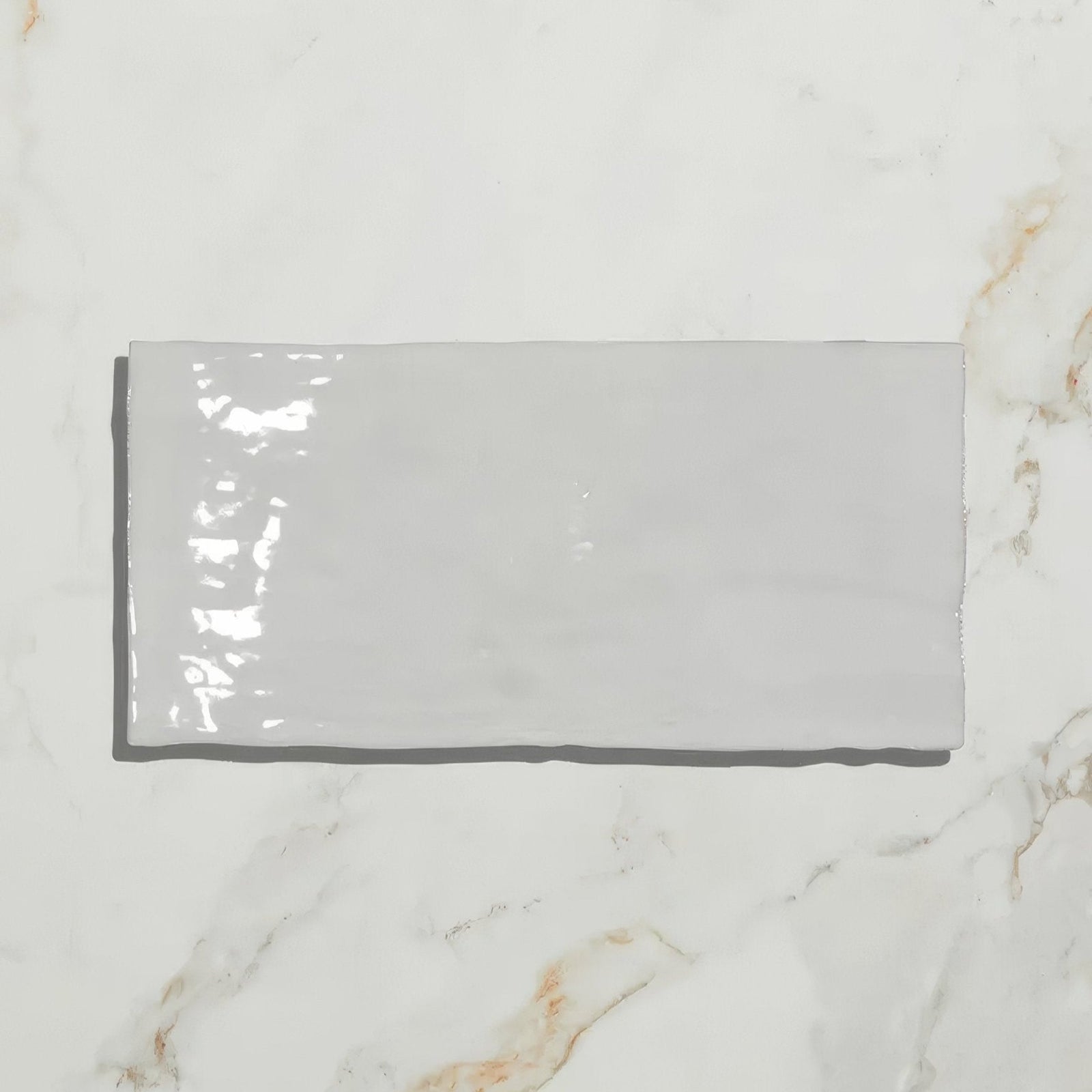 A sleek glossy gray rectangular shoreline ceramic chalk white tile with a smooth ceramic finish