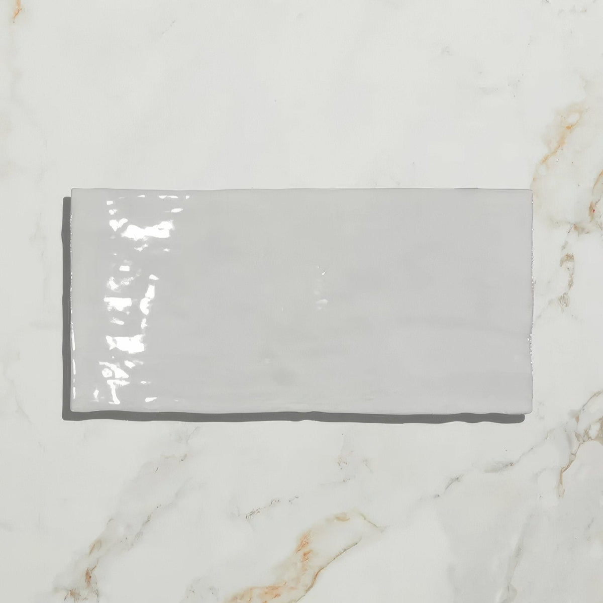 A sleek glossy gray rectangular shoreline ceramic chalk white tile with a smooth ceramic finish