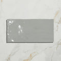 A sleek glossy gray Shoreline ceramic shingle tile with a smooth reflective surface for roofing or siding