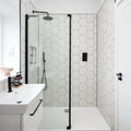 Modern black-framed glass shower enclosure with white hexagonal Signature Porcelain Pearl White tiles and minimalist design