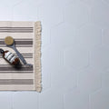 White hexagonal porcelain tiles form a clean modern bathroom floor in signature porcelain pearl white finish