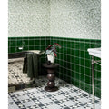 A glossy emerald green silk screen ceramic tile with a smooth reflective surface used for bathroom walls