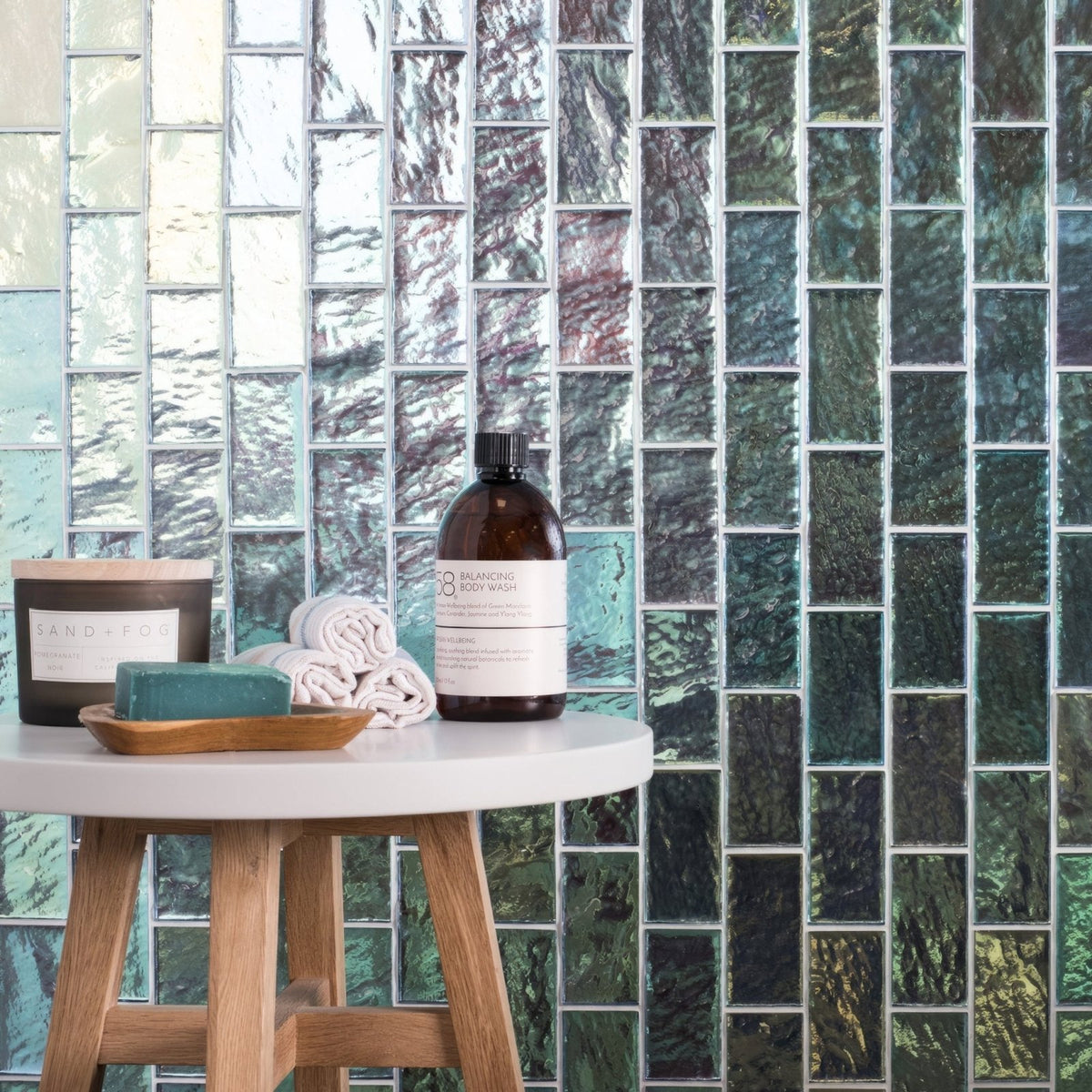 Silver Gloss Mosaic Radiance iridescent green and blue glass mosaic with an amber body wash bottle